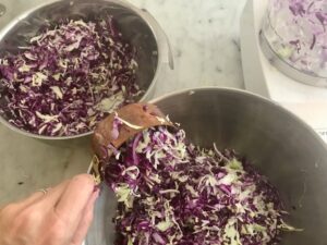 Scoop some shredded cabbage into a second mixing bowl.