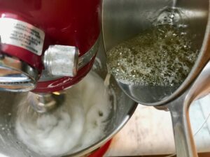 Pouring sugar syrup into meringue mixture