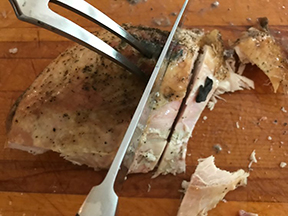 Turkey breast cut into slices with a knife