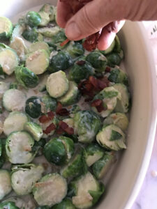 Sliced green brussels sprouts sprinkled with chunks of bacon